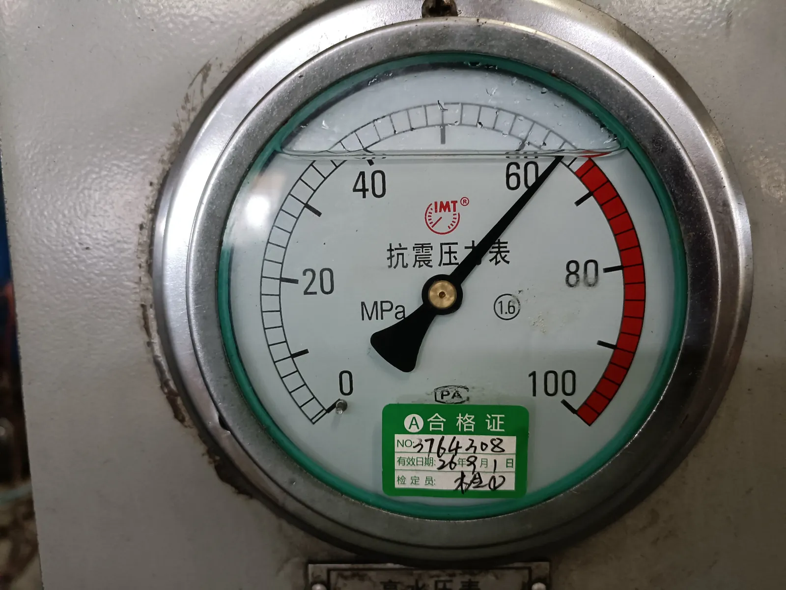 Test gauge graduated 0 to 100 MPa with its calibration label attached